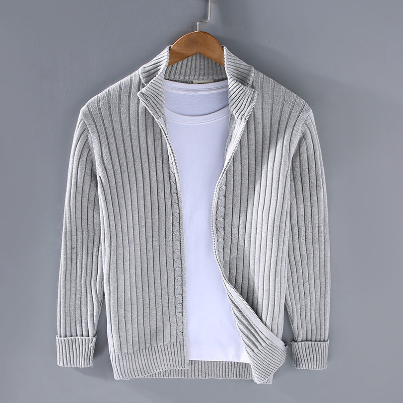 Gray ribbed sweater on a hanger against a gray background